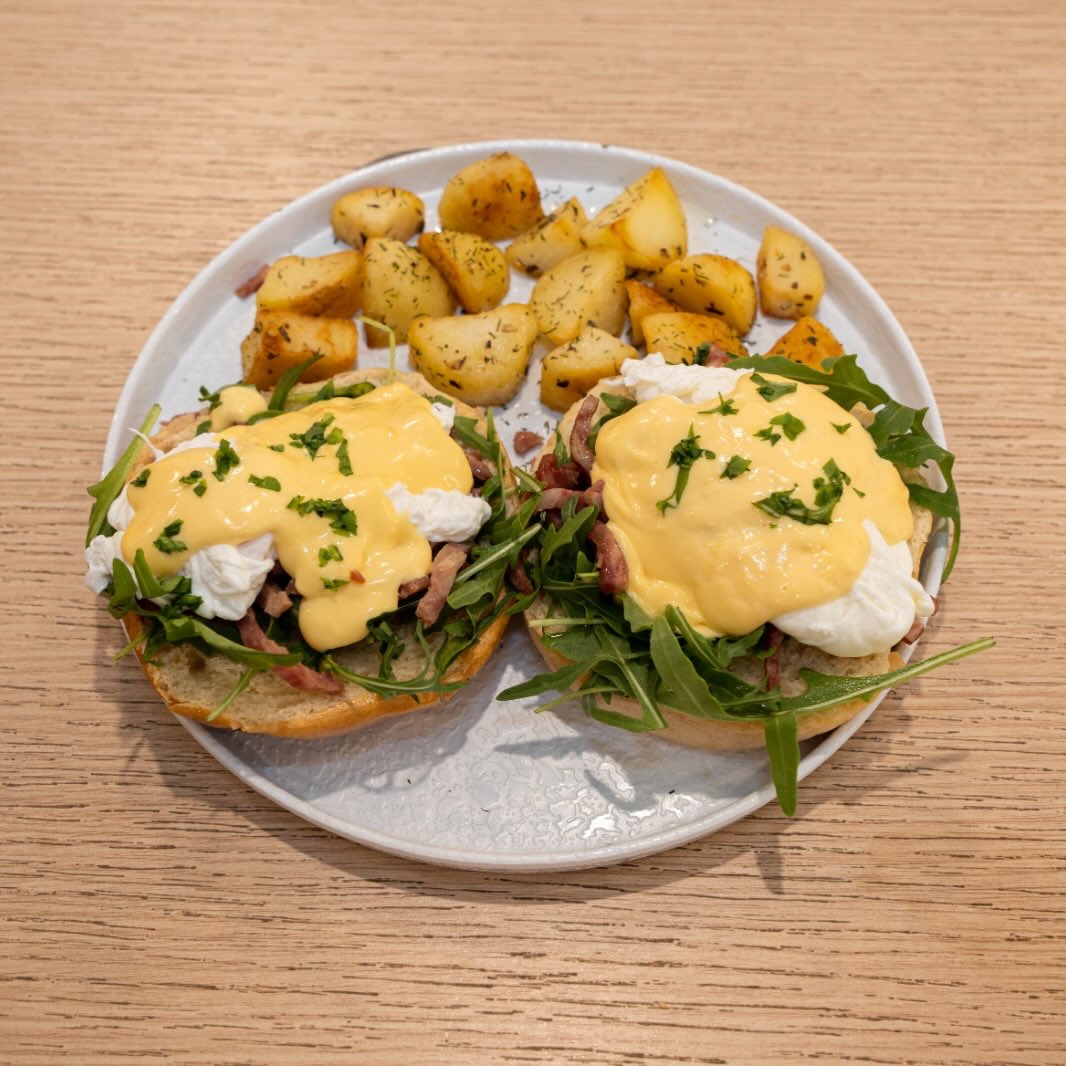 Desayuno. Huevos Benedictinos sobre pan de mollete blanco, salsa holandesa, bacon o salmón, patatas fritas o ensalada.