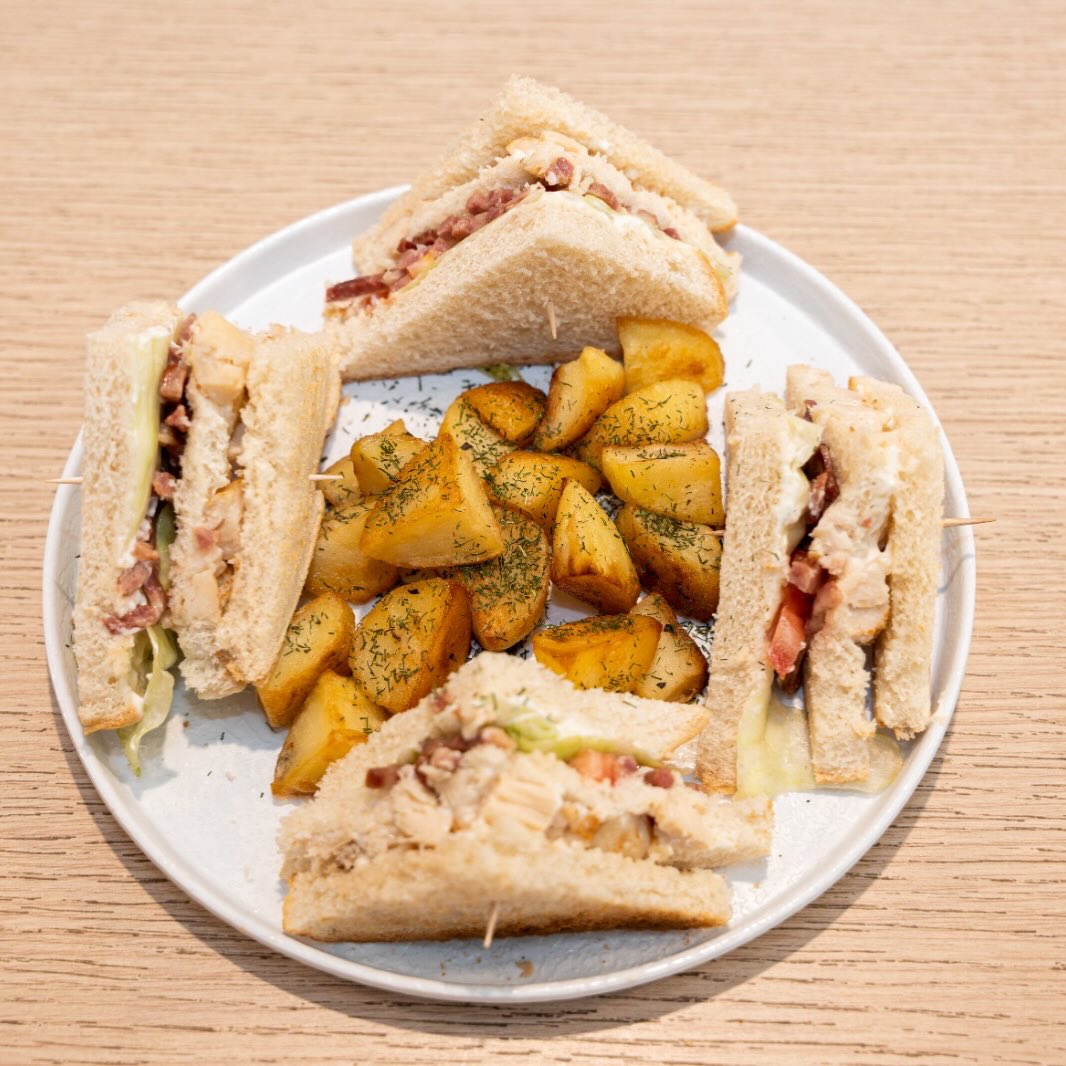 Desayuno. Sandwich XL con bacon, tomate, pollo, lechuga, queso y mayonesa, acompañado con patatas fritas en dados.