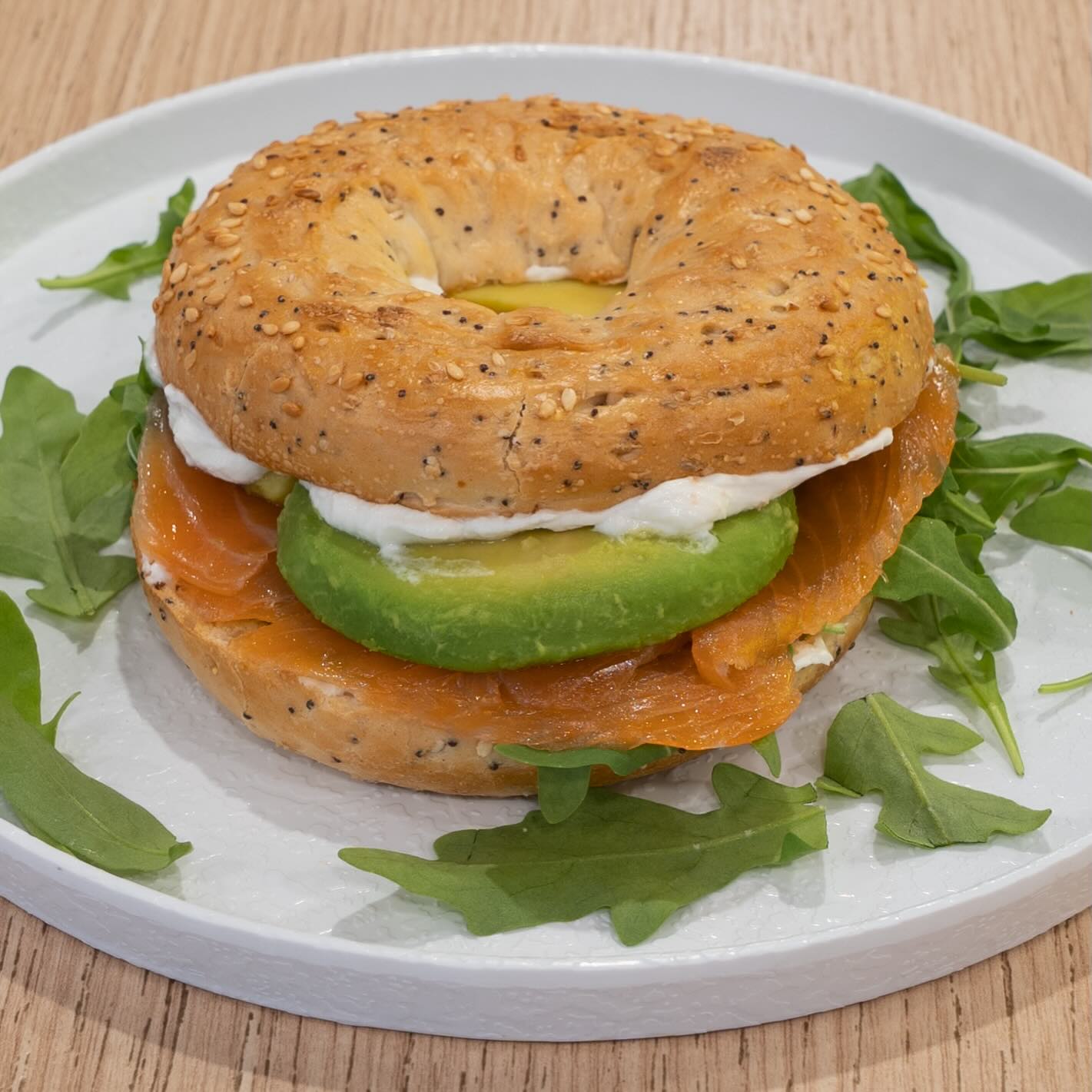 Bagel con queso crema, rúcula, salmón y aguacate.